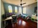Comfortable bedroom featuring multiple windows, hardwood floors, a ceiling fan, and a dedicated desk area at 18018 Malakai Isle Dr, Tampa, FL 33647
