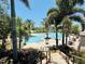 Elegant community pool area with palm trees, umbrellas, and lounge chairs at 18018 Malakai Isle Dr, Tampa, FL 33647