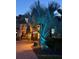 Home exterior with striking palm tree illuminated with strategic uplighting at 18018 Malakai Isle Dr, Tampa, FL 33647