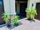 Inviting front porch with decorative brickwork, black rock landscaping, and desert style plants at 18018 Malakai Isle Dr, Tampa, FL 33647
