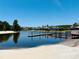 Picturesque lake view with sandy beach and dock, showcasing waterfront homes with tropical landscaping at 18018 Malakai Isle Dr, Tampa, FL 33647