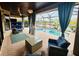 Enclosed patio area with a pool view, comfortable seating, and stylish decor at 18018 Malakai Isle Dr, Tampa, FL 33647