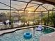 Screened pool featuring water views, bistro lights, lounge chairs and inflatables for relaxing at 18018 Malakai Isle Dr, Tampa, FL 33647