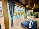 Covered lanai with pool featuring inviting blue furniture, tropical plants, and beautiful water views at 18018 Malakai Isle Dr, Tampa, FL 33647