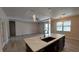 Kitchen island with stone countertop, undermount sink, and view of the living room with hardwood floors at 3269 Ponce De Leon Blvd, North Port, FL 34291