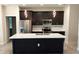 Modern kitchen with stainless steel appliances, dark wood cabinetry, and a center island with white countertop at 3269 Ponce De Leon Blvd, North Port, FL 34291