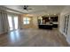 Open-concept living room featuring hardwood floors, a modern ceiling fan, and a view to the kitchen at 3269 Ponce De Leon Blvd, North Port, FL 34291