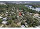 Wide aerial view of a neighborhood with lush trees and a lake in the distance at 404 Courtney Dr, Temple Terrace, FL 33617