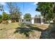Backyard featuring green grass, a shed, and a screened porch at 404 Courtney Dr, Temple Terrace, FL 33617