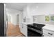 Updated kitchen with stainless steel appliances, white cabinets, and an adjacent living area at 404 Courtney Dr, Temple Terrace, FL 33617