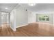 Spacious living room featuring refinished hardwood floors, neutral paint, and large windows at 404 Courtney Dr, Temple Terrace, FL 33617
