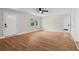 Bright living room featuring wood flooring, fresh paint, ceiling fan, and an exterior entrance at 404 Courtney Dr, Temple Terrace, FL 33617