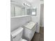 Bright bathroom featuring white fixtures, tile, and neutral countertop with a view into the bathroom at 7604 Tyson Dr, Port Richey, FL 34668