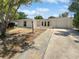 Charming single-story home featuring a driveway and well-maintained front yard under a blue sky at 7604 Tyson Dr, Port Richey, FL 34668
