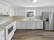 Clean kitchen with white cabinetry, modern appliances, and a window that brings in natural light at 7604 Tyson Dr, Port Richey, FL 34668