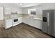 Well-equipped kitchen with white cabinets, appliances, and new wood-look flooring at 7604 Tyson Dr, Port Richey, FL 34668