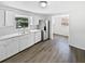 Bright kitchen featuring white cabinets, modern stainless steel appliances, and durable laminate flooring at 7604 Tyson Dr, Port Richey, FL 34668