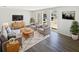 Cozy living room with gray furniture, decorative rug, and plenty of natural light from the large windows at 7604 Tyson Dr, Port Richey, FL 34668