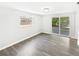 Bright living room with modern laminate flooring, a large window, and sliding glass doors at 7604 Tyson Dr, Port Richey, FL 34668