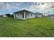 Home's back exterior with a covered patio and a well-maintained lawn at 9 Bunker Pl, Rotonda West, FL 33947