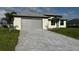 Paver driveway leads to a spacious two-car garage with a well-maintained front lawn at 9 Bunker Pl, Rotonda West, FL 33947