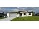 Beautiful single-story home featuring a gray roof, gray garage door and manicured lawn at 9 Bunker Pl, Rotonda West, FL 33947
