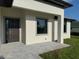 Modern home exterior featuring a covered entrance and a dark front door with stone pavers at 9 Bunker Pl, Rotonda West, FL 33947