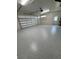 Spacious two-car garage featuring a durable, epoxy-coated floor, a large overhead door, and ample lighting at 9 Bunker Pl, Rotonda West, FL 33947