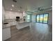 Open-concept kitchen with white cabinets, a large island, stainless appliances, and hardwood floors at 9 Bunker Pl, Rotonda West, FL 33947