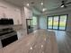 Modern kitchen with a large island, stainless steel appliances, white cabinets, and wood floors at 9 Bunker Pl, Rotonda West, FL 33947