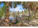 Wooden dock with boat lift overlooking the calm canal waters and tropical landscaping at 18430 Alphonse Cir, Port Charlotte, FL 33948