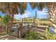 Wooden dock with boat lift overlooking the calm canal waters and tropical landscaping at 18430 Alphonse Cir, Port Charlotte, FL 33948