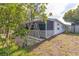A screened porch with white lattice and a peek at the side yard at 18430 Alphonse Cir, Port Charlotte, FL 33948