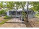 A screened porch with white lattice and a peek at the side yard at 18430 Alphonse Cir, Port Charlotte, FL 33948