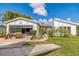Quaint home featuring white paint, gray trim, and a garage with a screened door at 18430 Alphonse Cir, Port Charlotte, FL 33948