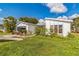 Quaint home featuring white paint, gray trim, and a garage with a screened door at 18430 Alphonse Cir, Port Charlotte, FL 33948