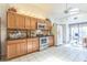 A kitchen with wooden cabinets, tile flooring, stainless steel appliances, and a large window at 18430 Alphonse Cir, Port Charlotte, FL 33948