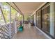 View of the tiled porch, featuring a screened area with lattice and access to the interior via sliding glass doors at 18430 Alphonse Cir, Port Charlotte, FL 33948