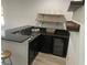 A modern bar area featuring dark granite countertops, a sink, wine refrigerator, and floating shelves at 302 Coco Plum Ct, Oldsmar, FL 34677