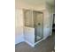 Bathroom featuring a glass-enclosed shower with hooks and a door to an adjacent room, complemented by tiled floors at 302 Coco Plum Ct, Oldsmar, FL 34677