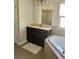 Bathroom featuring a tub, dark cabinets, double sinks, large mirror and sink with tiled countertop and hardwood floor at 302 Coco Plum Ct, Oldsmar, FL 34677