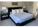 Cozy bedroom with a black platform bed, three decorative pillows, bedside tables, and plush carpet at 302 Coco Plum Ct, Oldsmar, FL 34677