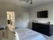 Comfortable bedroom with black dresser, ceiling fan, and view of the adjacent bathroom featuring a glass shower at 302 Coco Plum Ct, Oldsmar, FL 34677