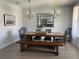 Elegant dining room with a wooden table, upholstered chairs, bench seating, and modern chandeliers at 302 Coco Plum Ct, Oldsmar, FL 34677