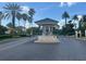 Elegant gated community entrance with meticulously landscaped grounds and swaying palm trees at 302 Coco Plum Ct, Oldsmar, FL 34677