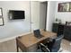 Contemporary office space featuring a wooden desk, sleek rolling chair, TV, and bar cabinet at 302 Coco Plum Ct, Oldsmar, FL 34677