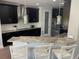 Modern kitchen with black cabinets, granite countertops, stainless steel appliances and island with seating at 302 Coco Plum Ct, Oldsmar, FL 34677