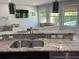 Open-concept kitchen with granite countertops overlooking the living area and pool at 302 Coco Plum Ct, Oldsmar, FL 34677