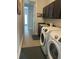 A modern laundry room with black cabinets, neutral paint, and high end front load washer and dryer at 302 Coco Plum Ct, Oldsmar, FL 34677
