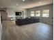 Spacious living room with sectional sofa, recessed lighting, large windows, media console, and light gray floors at 302 Coco Plum Ct, Oldsmar, FL 34677